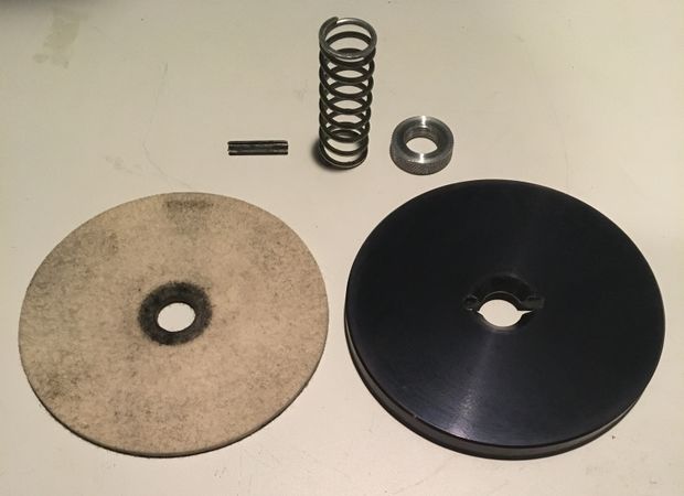 Spring pin, spring, knurled nut, felt pad, and pressure plate disassembled for cleaning.